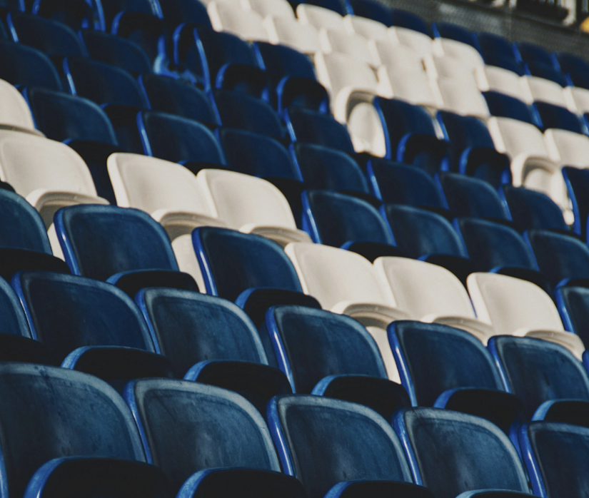 Empty fan seats in a stadium. Photo by Aubin Kirch from Pexels